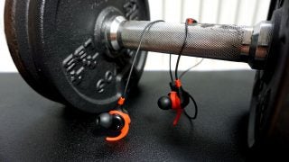 KitSound Immerse Active earphones on gym weight equipment.