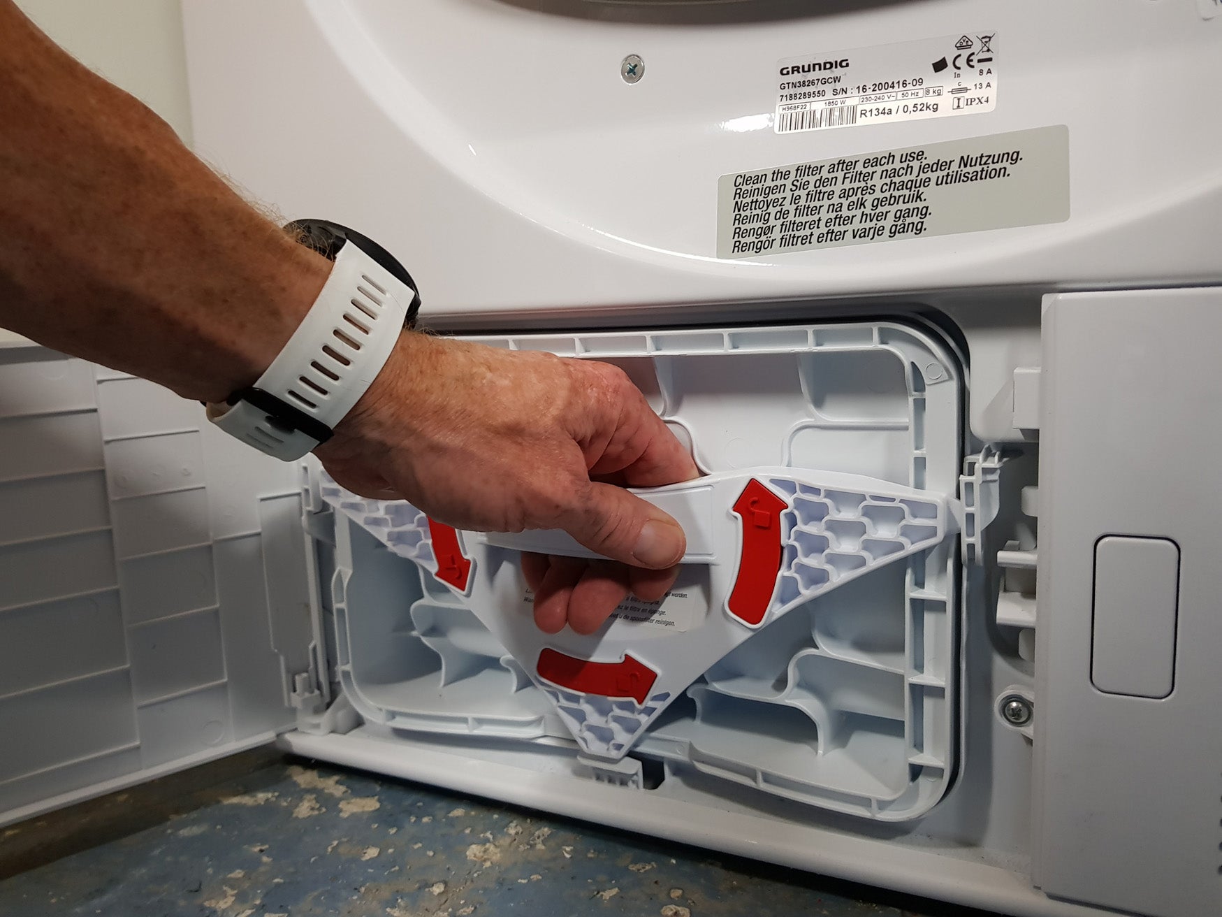 Person removing lint filter from Grundig dryer