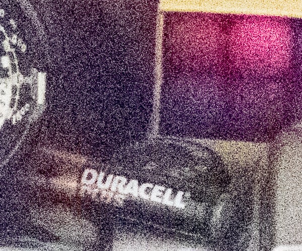 Grainy close-up of a Duracell battery with noise artifacts.