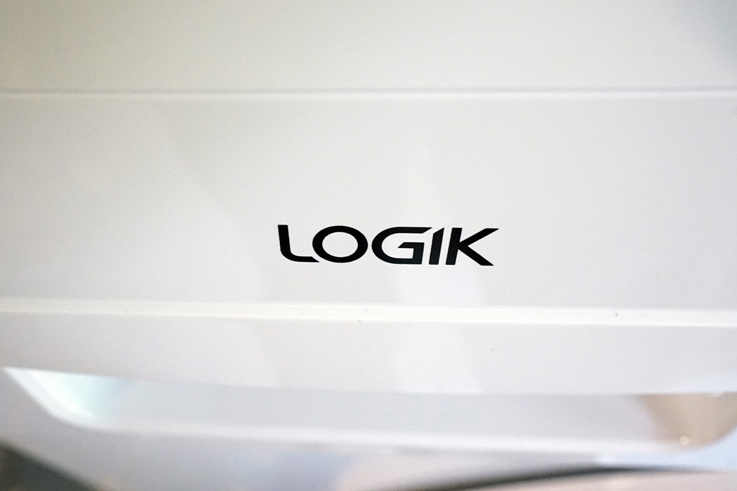 Close-up of a Logik washing machine logo.
