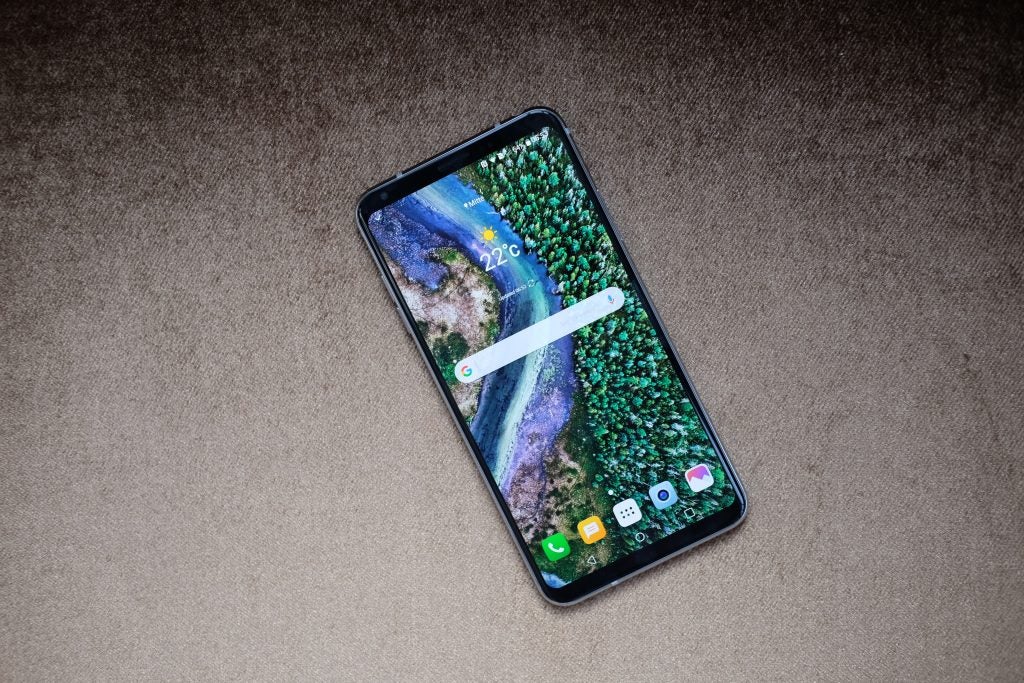 LG V30 smartphone displaying home screen on a textured surface.