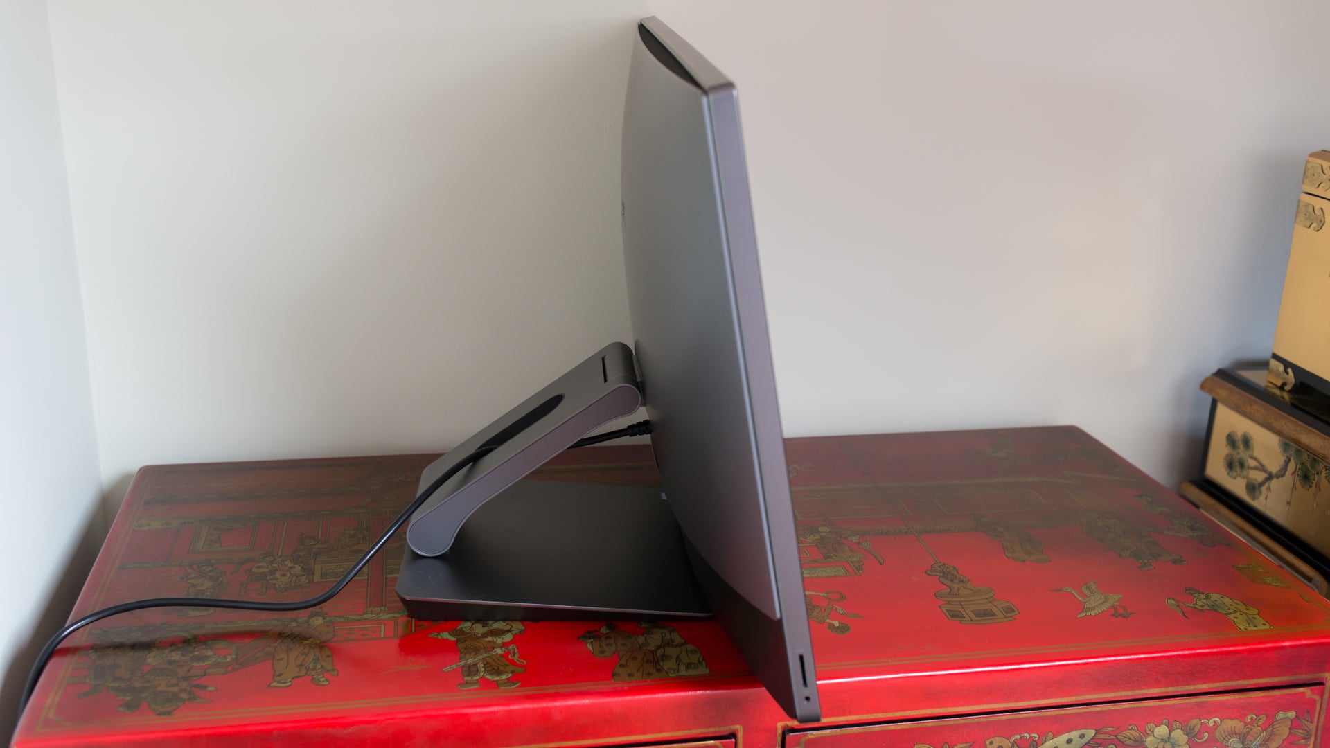 Side view of Dell XPS 27 All-in-One on red desk.