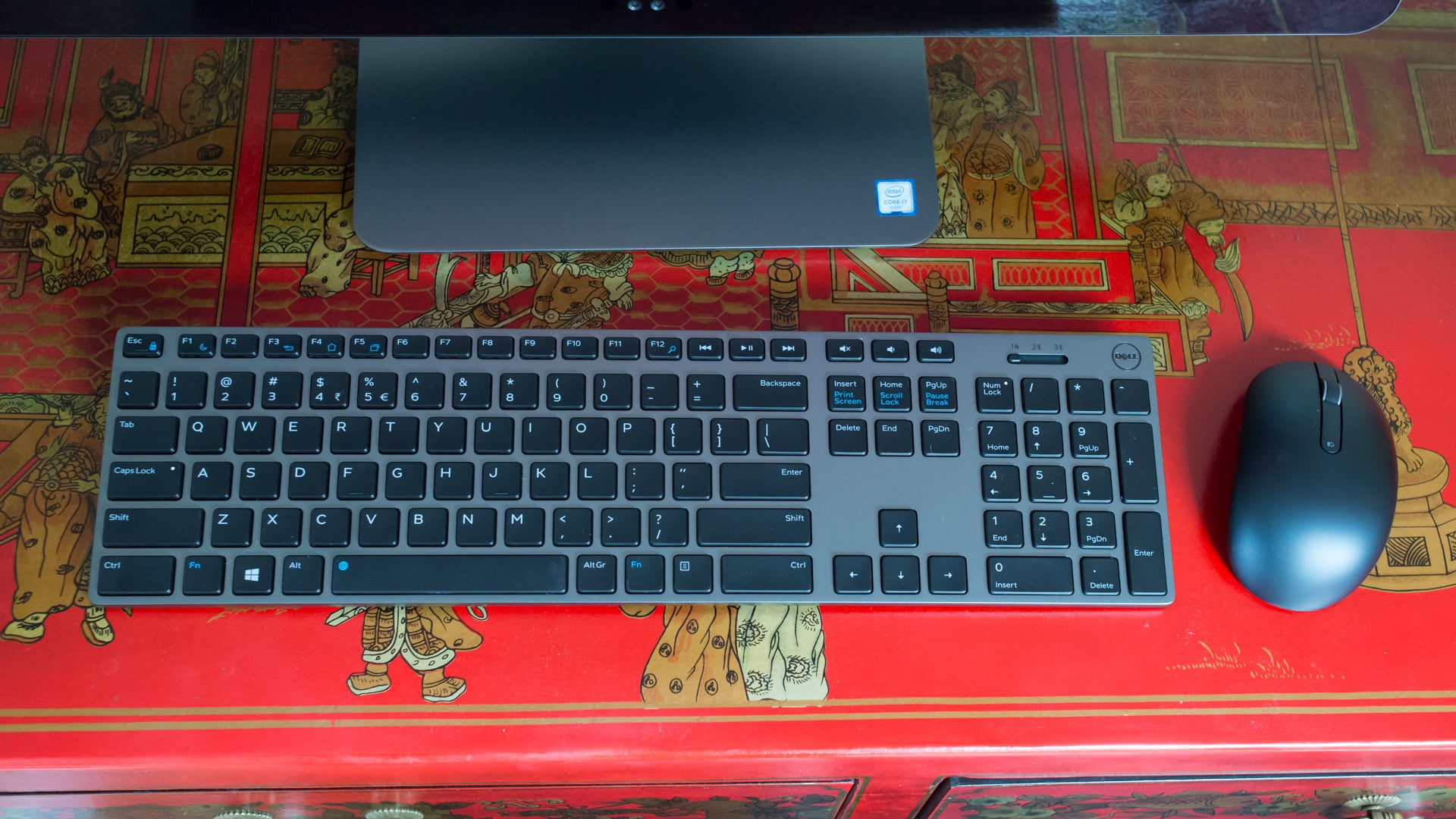 Dell keyboard and mouse on a decorative red desk.