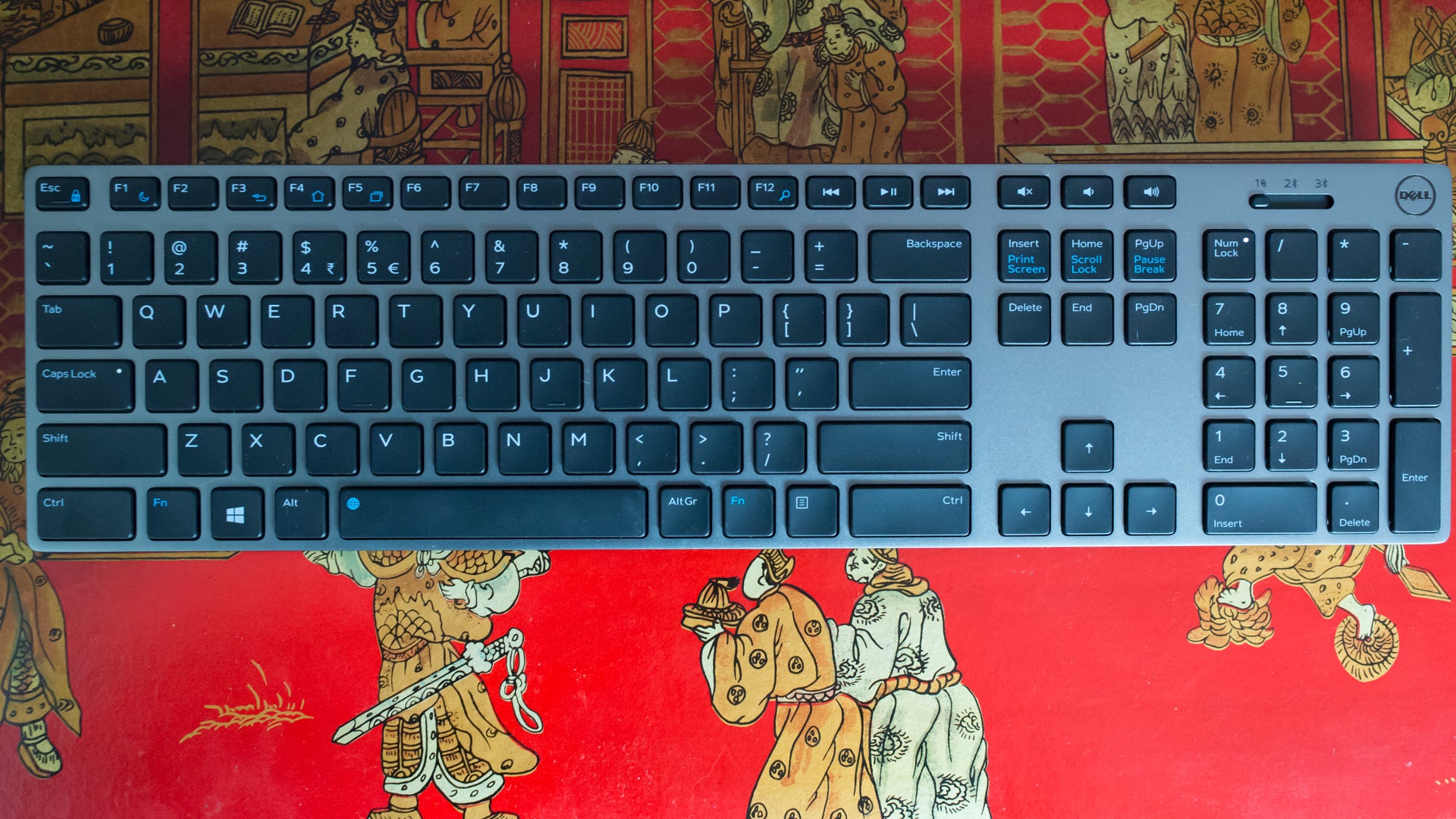 Dell XPS keyboard on patterned red background.