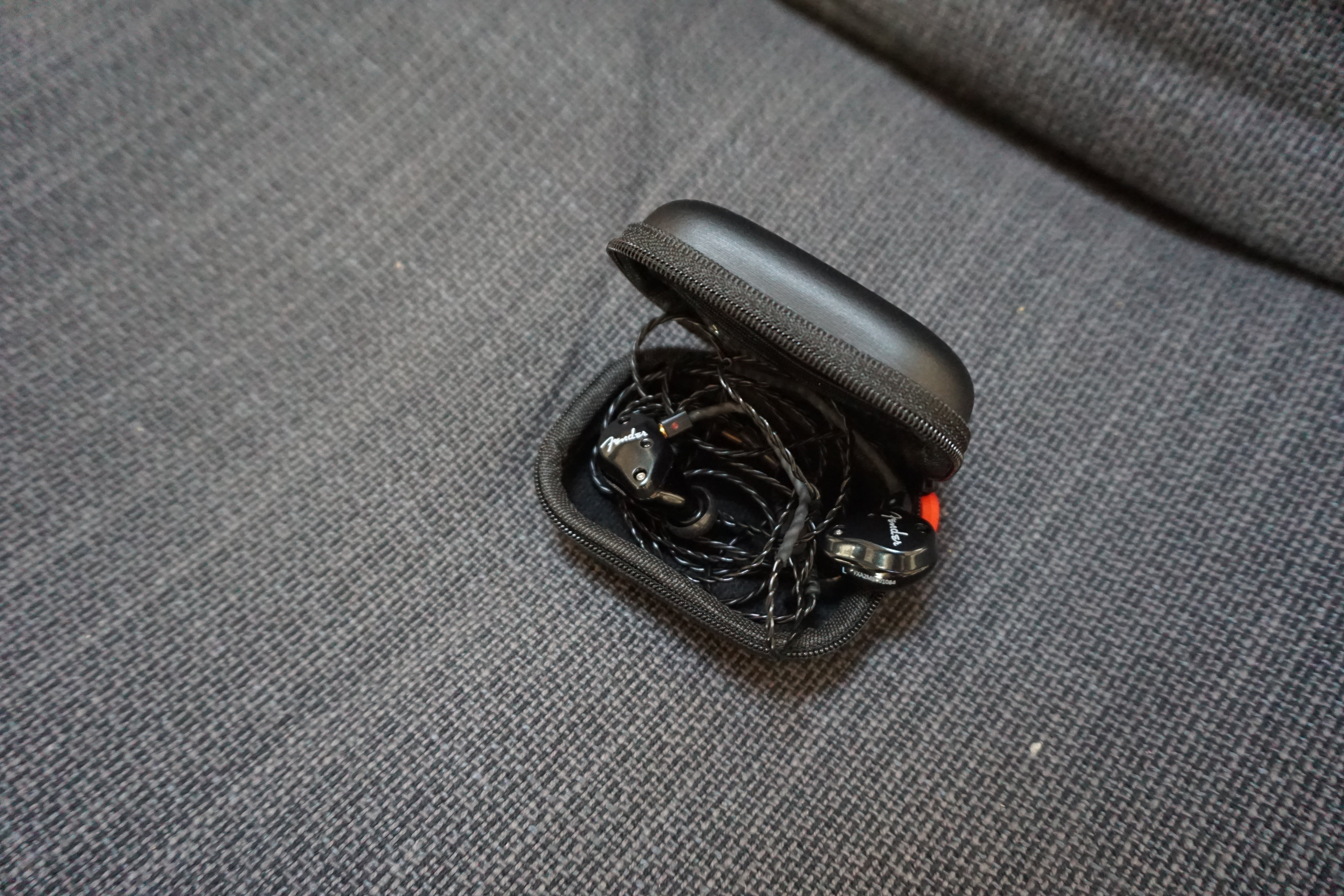 Fender FXA2 in-ear monitors with carrying case on fabric surface.