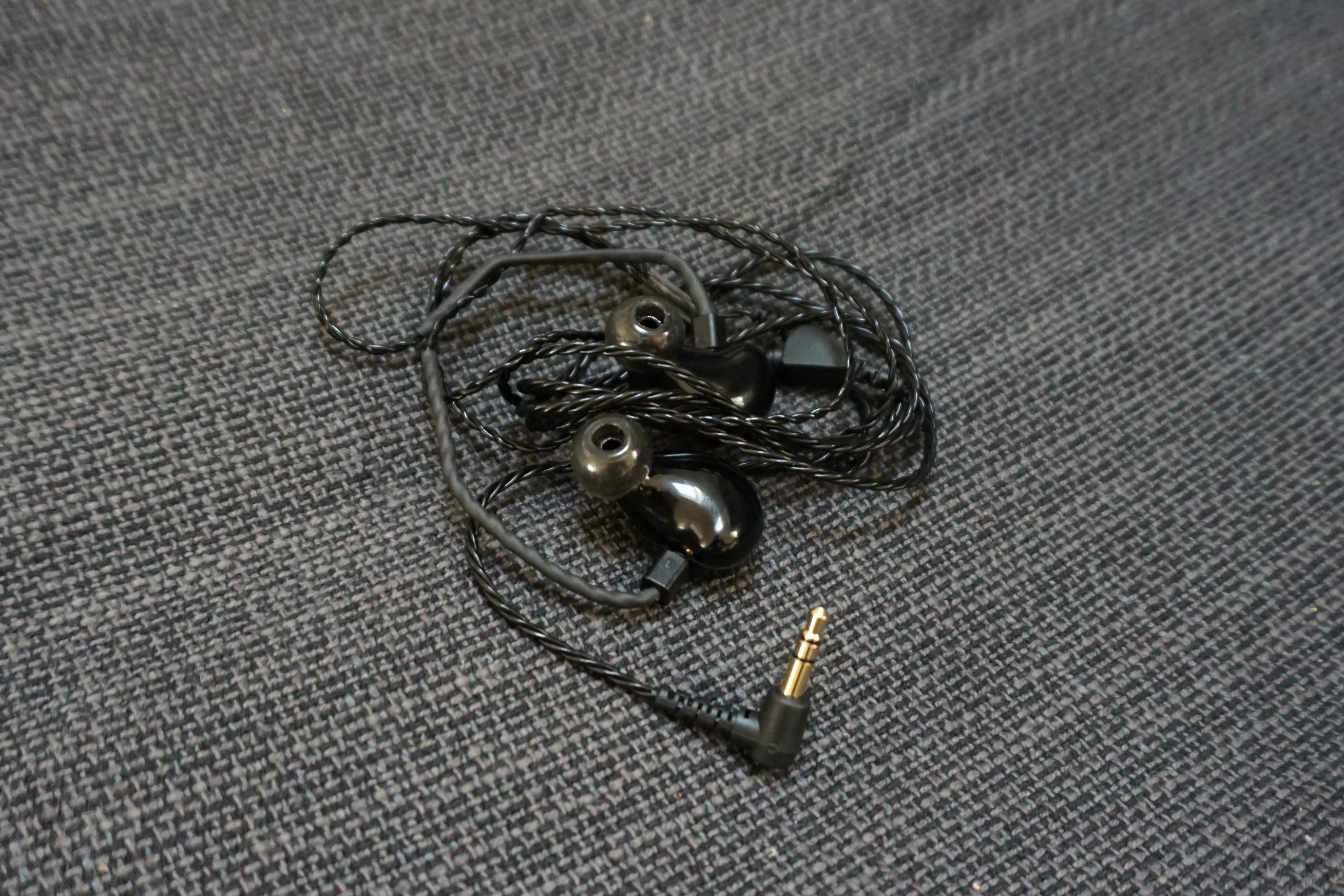 Fender FXA2 in-ear monitors with braided cable on fabric.