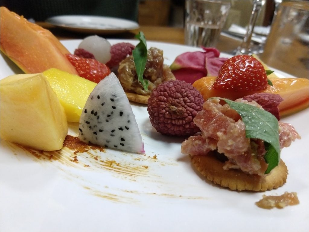 Assorted fresh fruits and snacks on a plate.