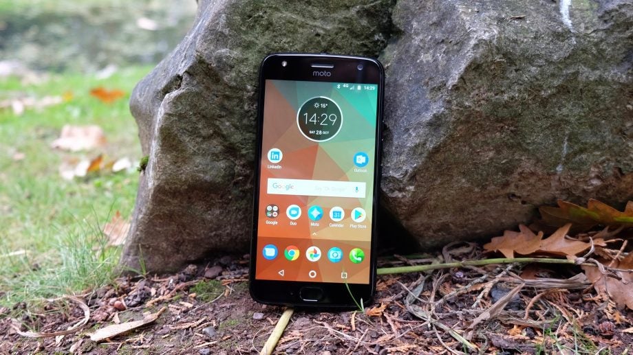 Moto X4 smartphone displayed outdoors on natural background.