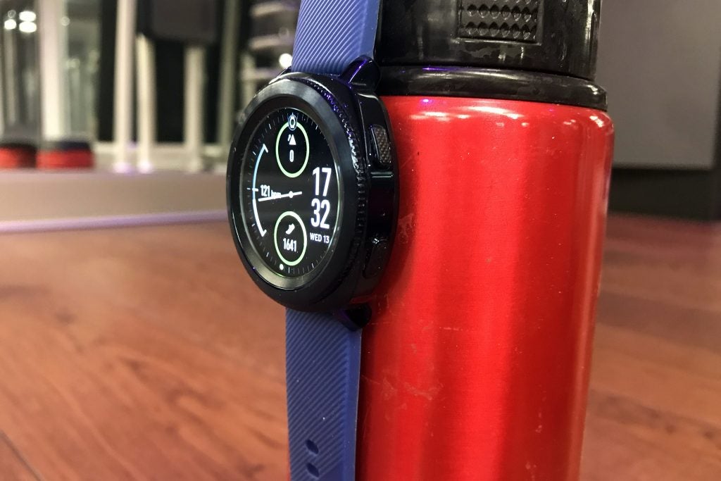 Samsung Gear Sport smartwatch on a red water bottle.