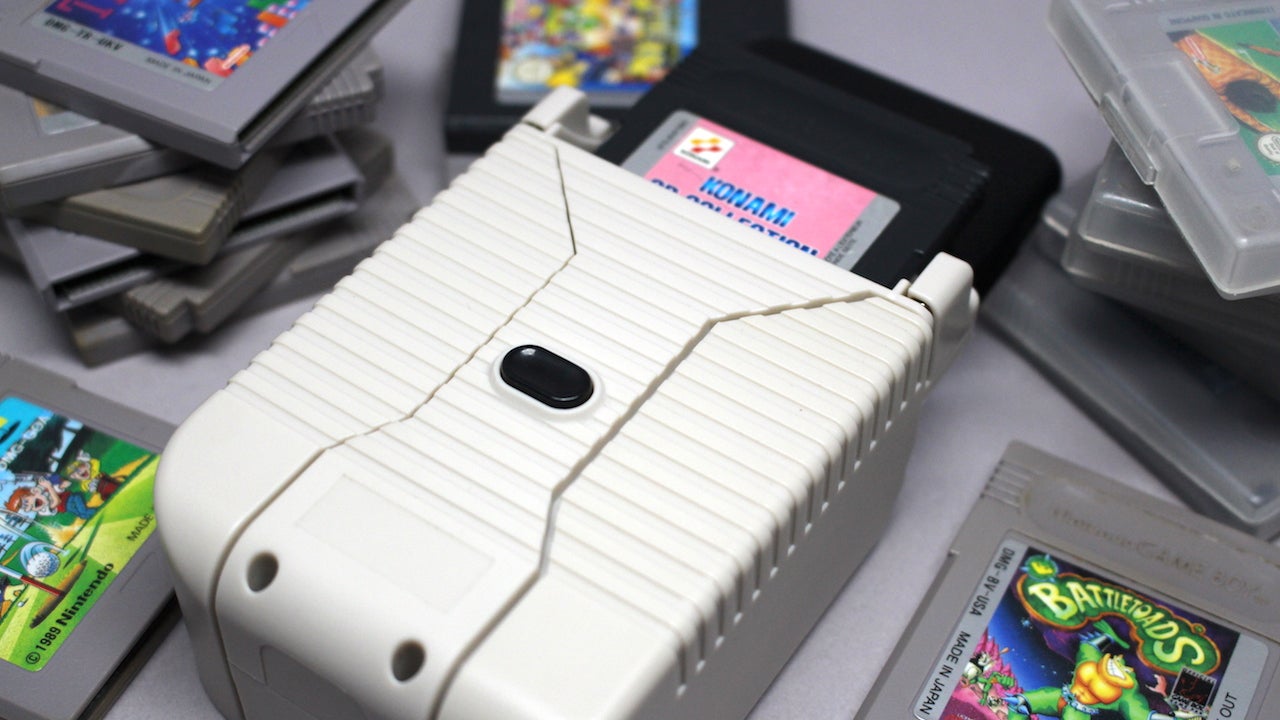 Hyperkin SmartBoy device surrounded by Game Boy cartridges.