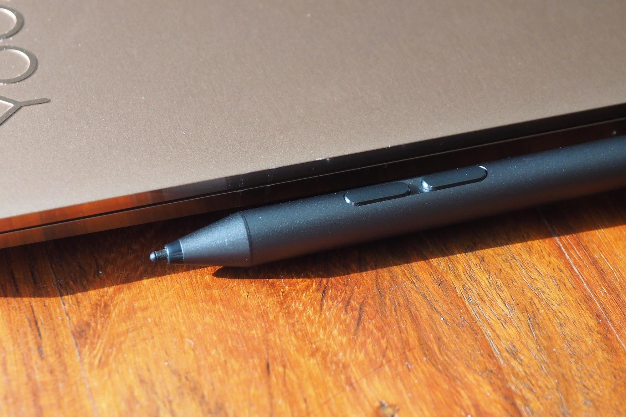 Close-up of Lenovo Yoga 920 with active pen on wooden surface.