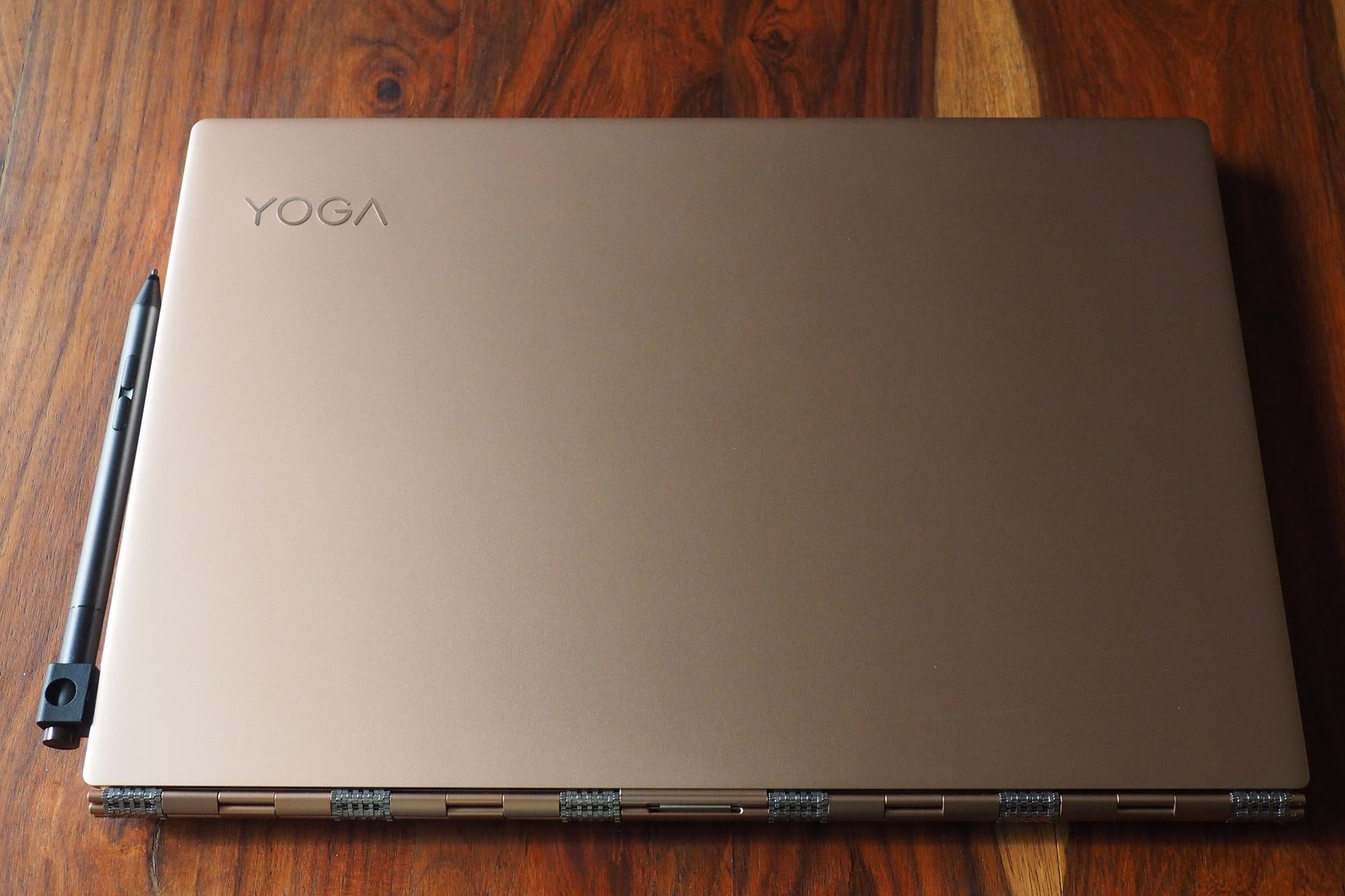 Lenovo Yoga 920 laptop closed on wooden surface with pen.