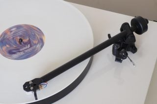 Rega Planar 1 turntable with spinning record and tonearm.