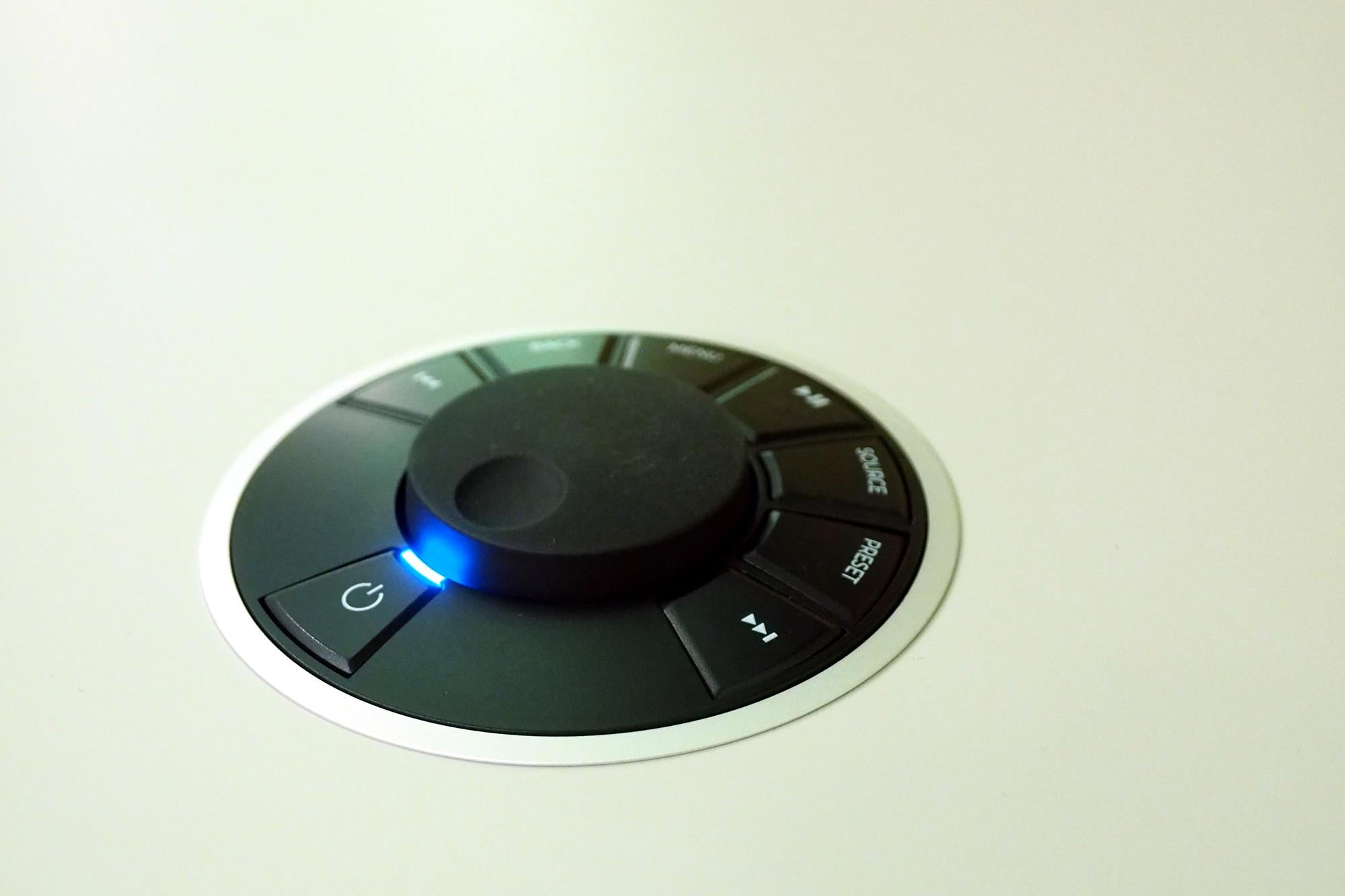 Close-up of Ruark Audio R7 Mk3 remote control with illuminated power button.