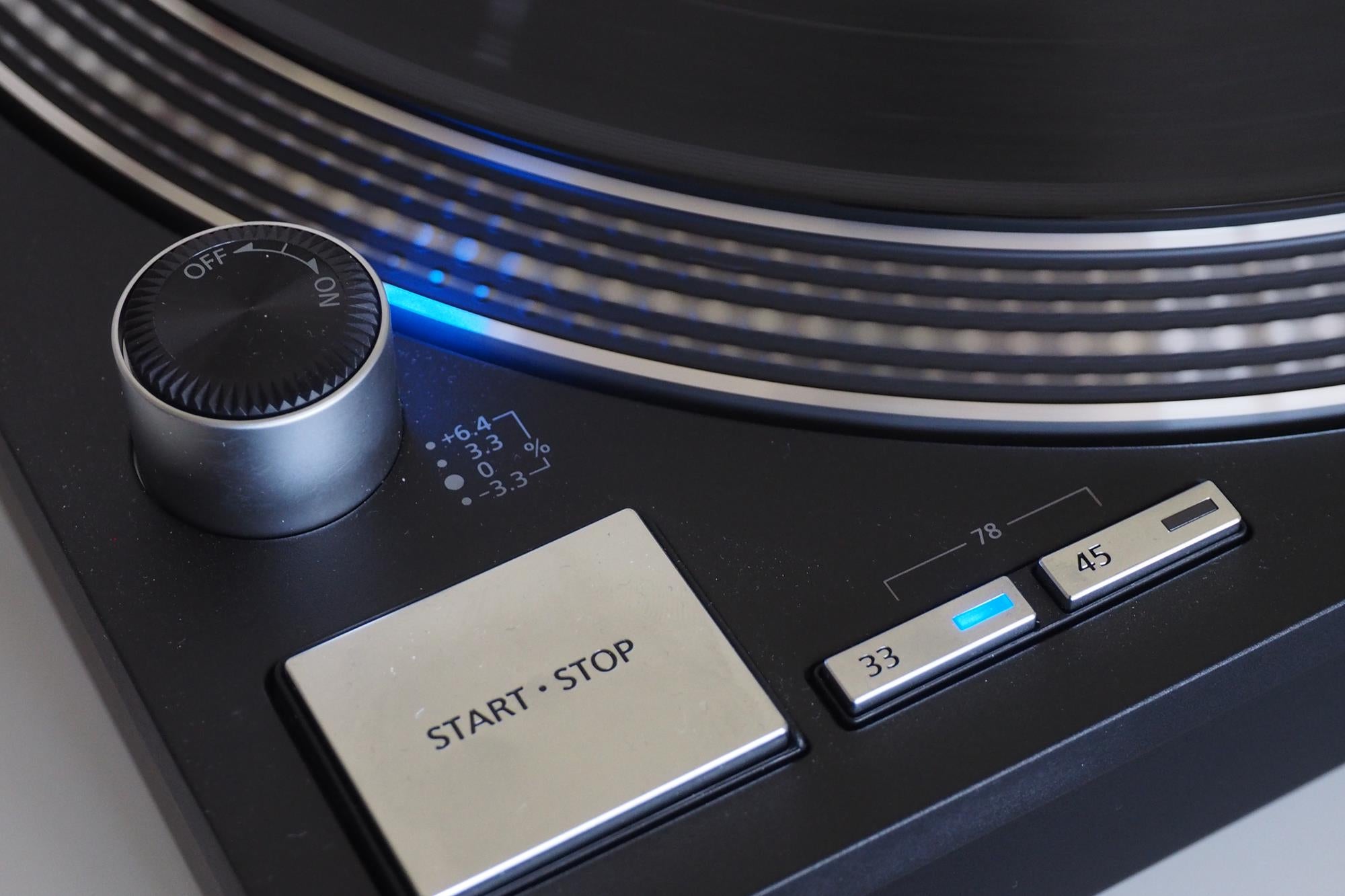 Close-up of Technics turntable pitch control and start/stop button.