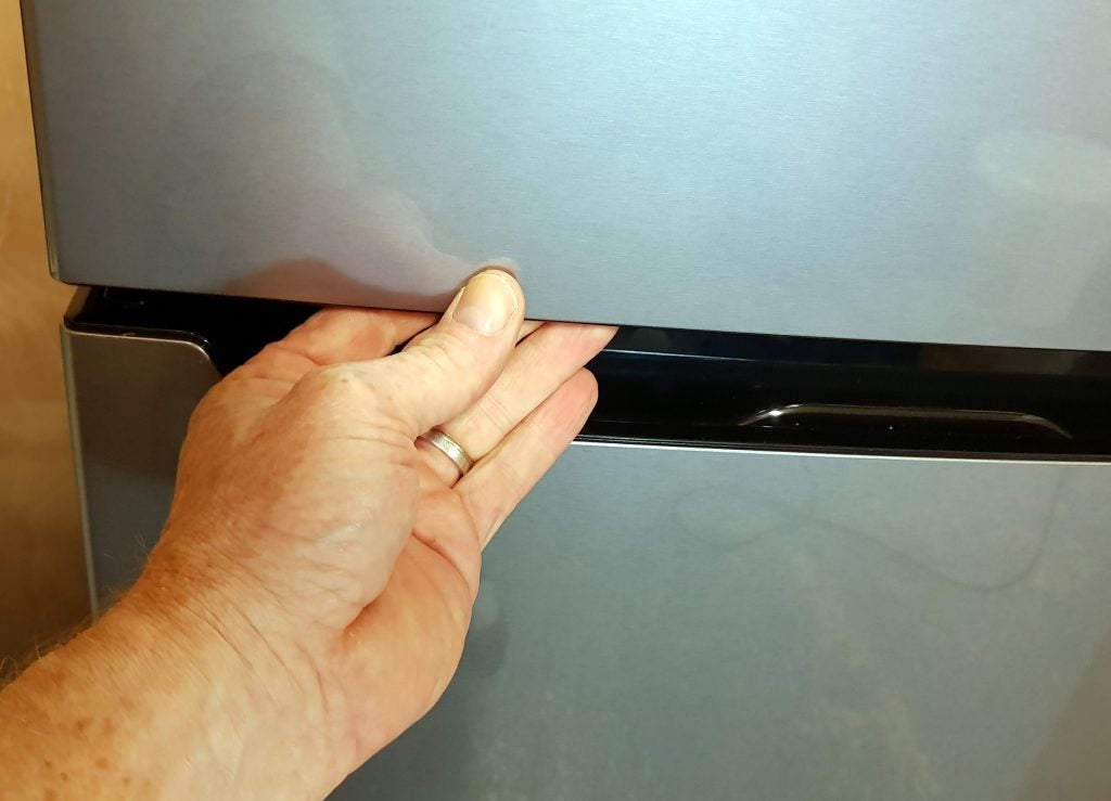 Hand opening a Hisense fridge freezer drawer.