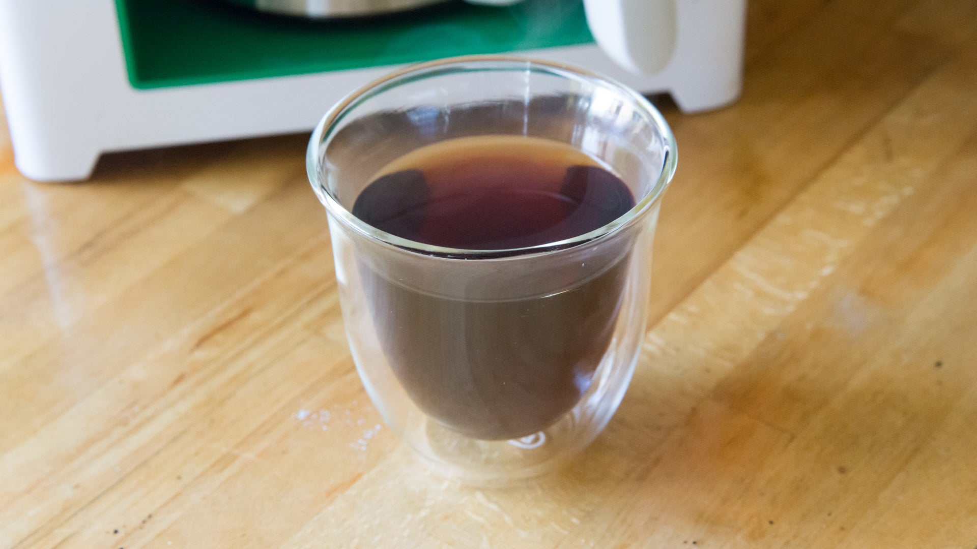 Freshly brewed coffee in glass cup with Bonaverde Berlin in background