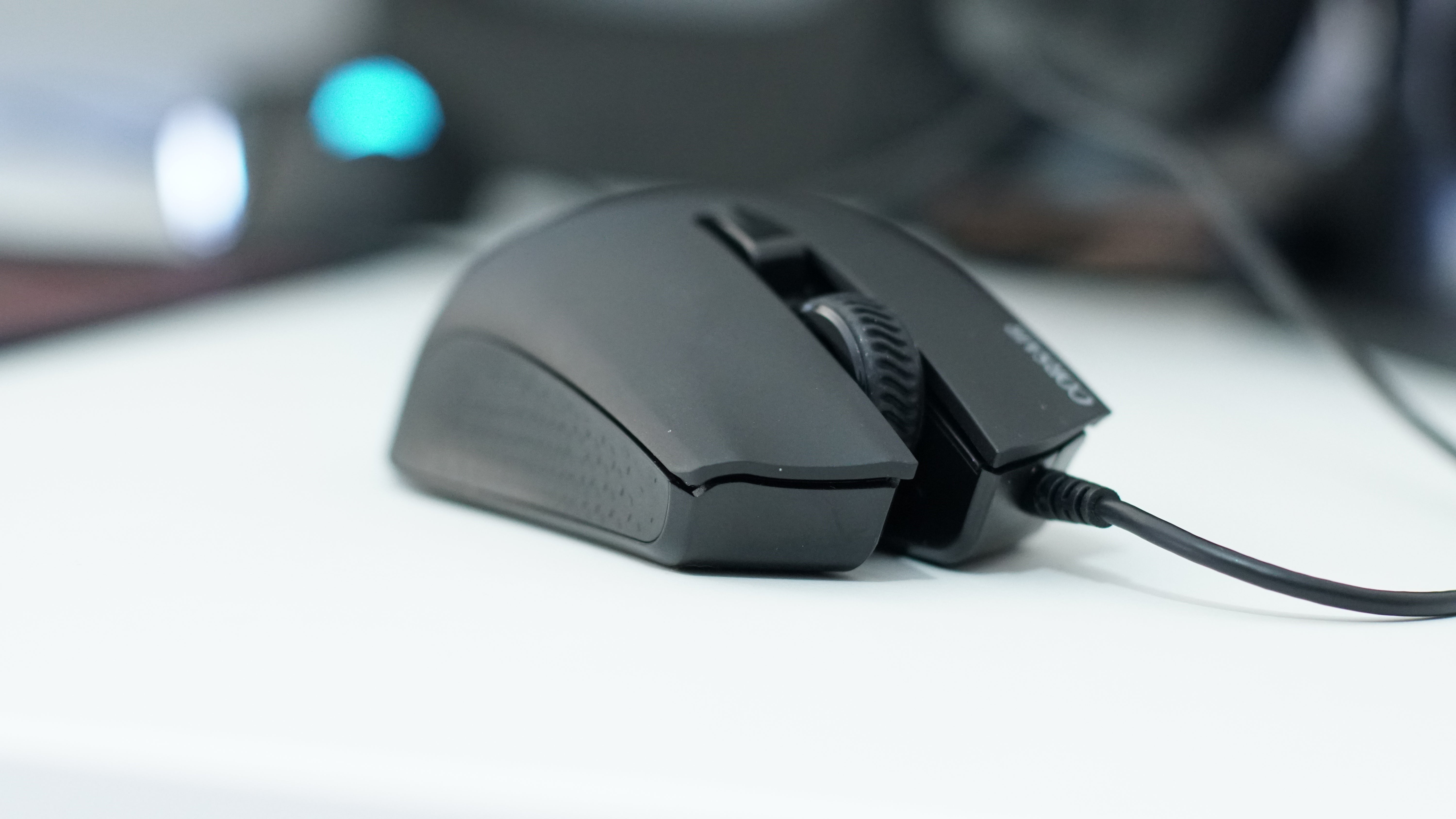Close-up of a Corsair Harpoon wired gaming mouse on a desk.