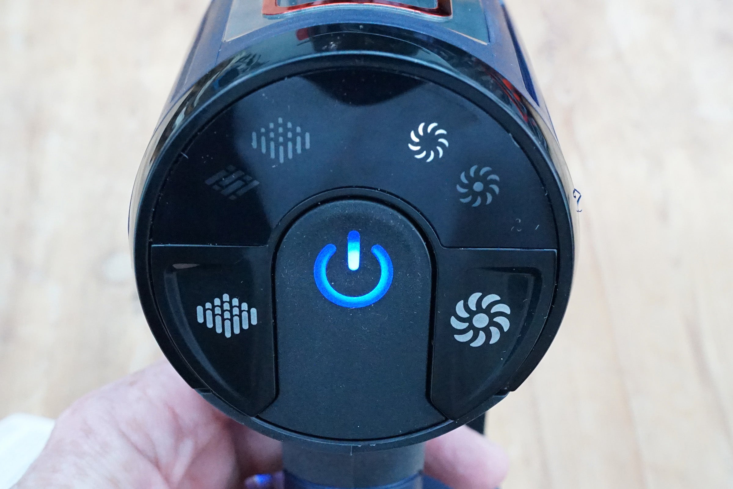 Close-up of Shark DuoClean vacuum cleaner power button and control icons.