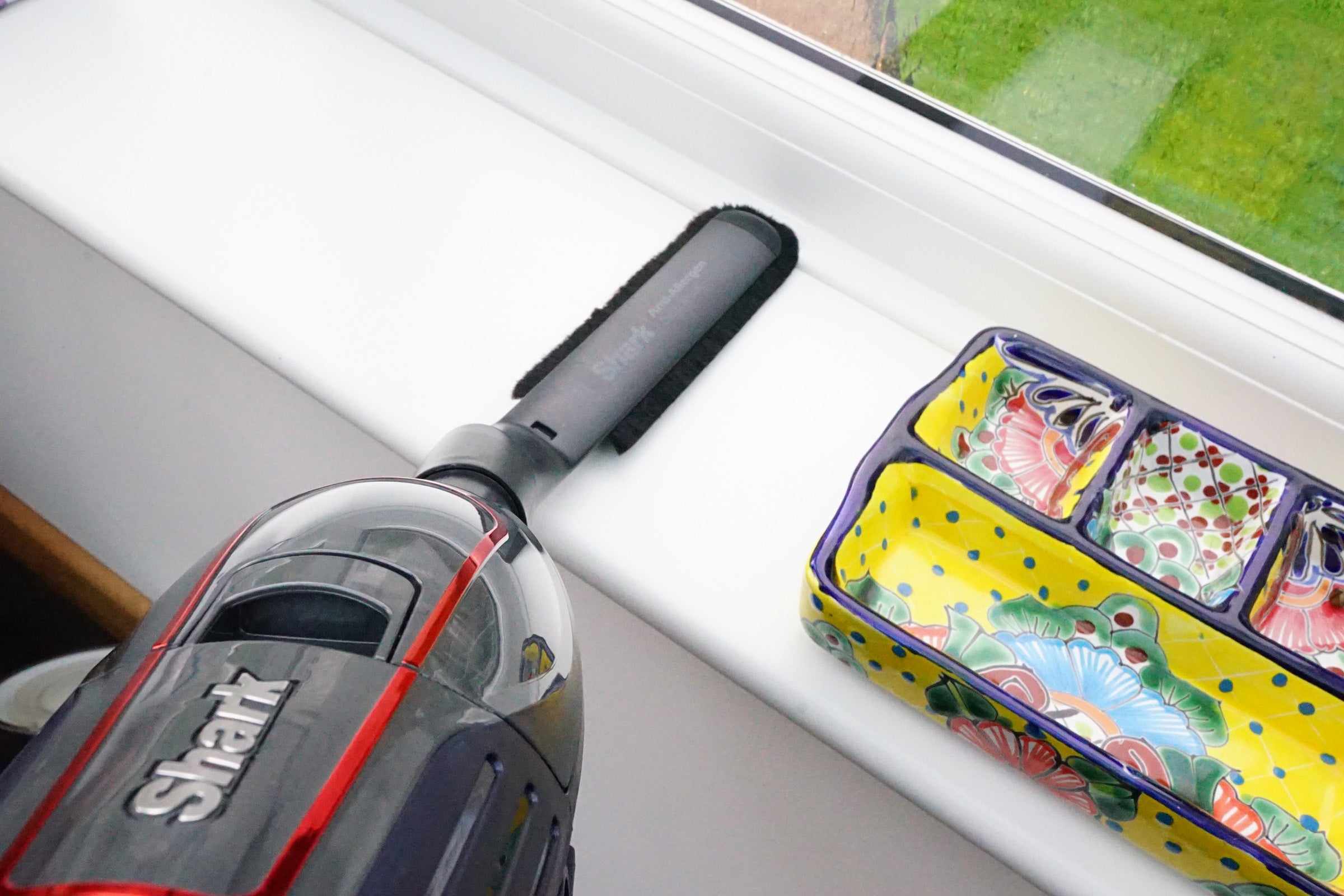 Shark DuoClean Cordless Vacuum by a window with colorful tray.