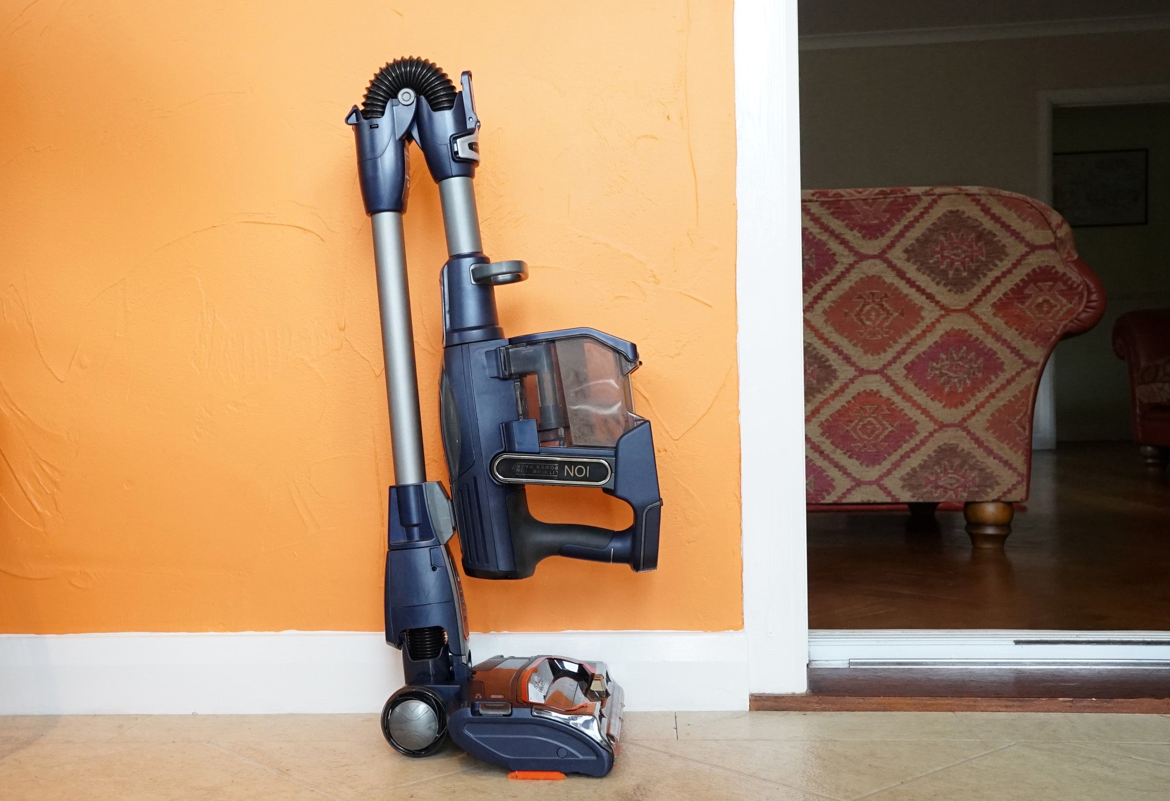 Shark DuoClean Cordless Vacuum cleaner against orange wall.