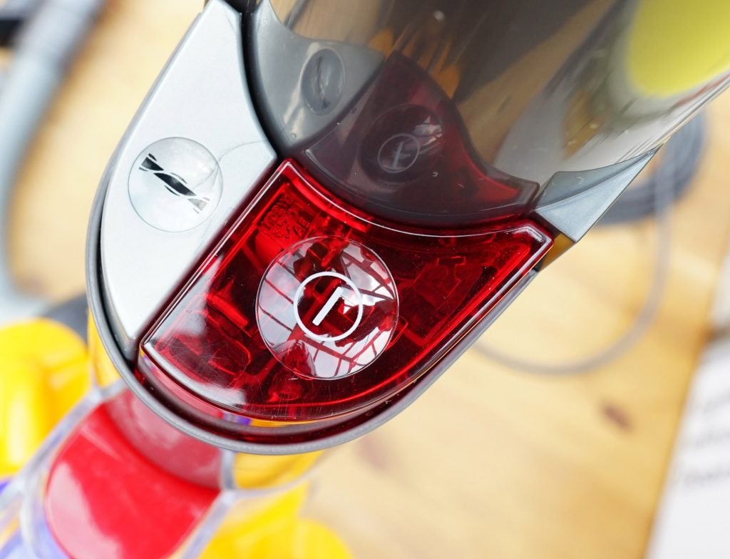 Close-up of the Dyson Light Ball vacuum's red cyclone release button.