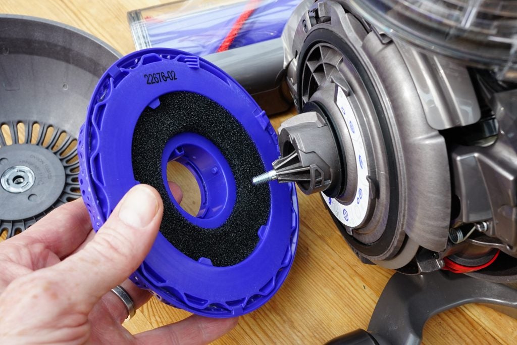 Dyson vacuum with hand holding a filter part.