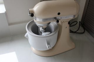 KitchenAid stand mixer with ice cream maker attachment on counter.