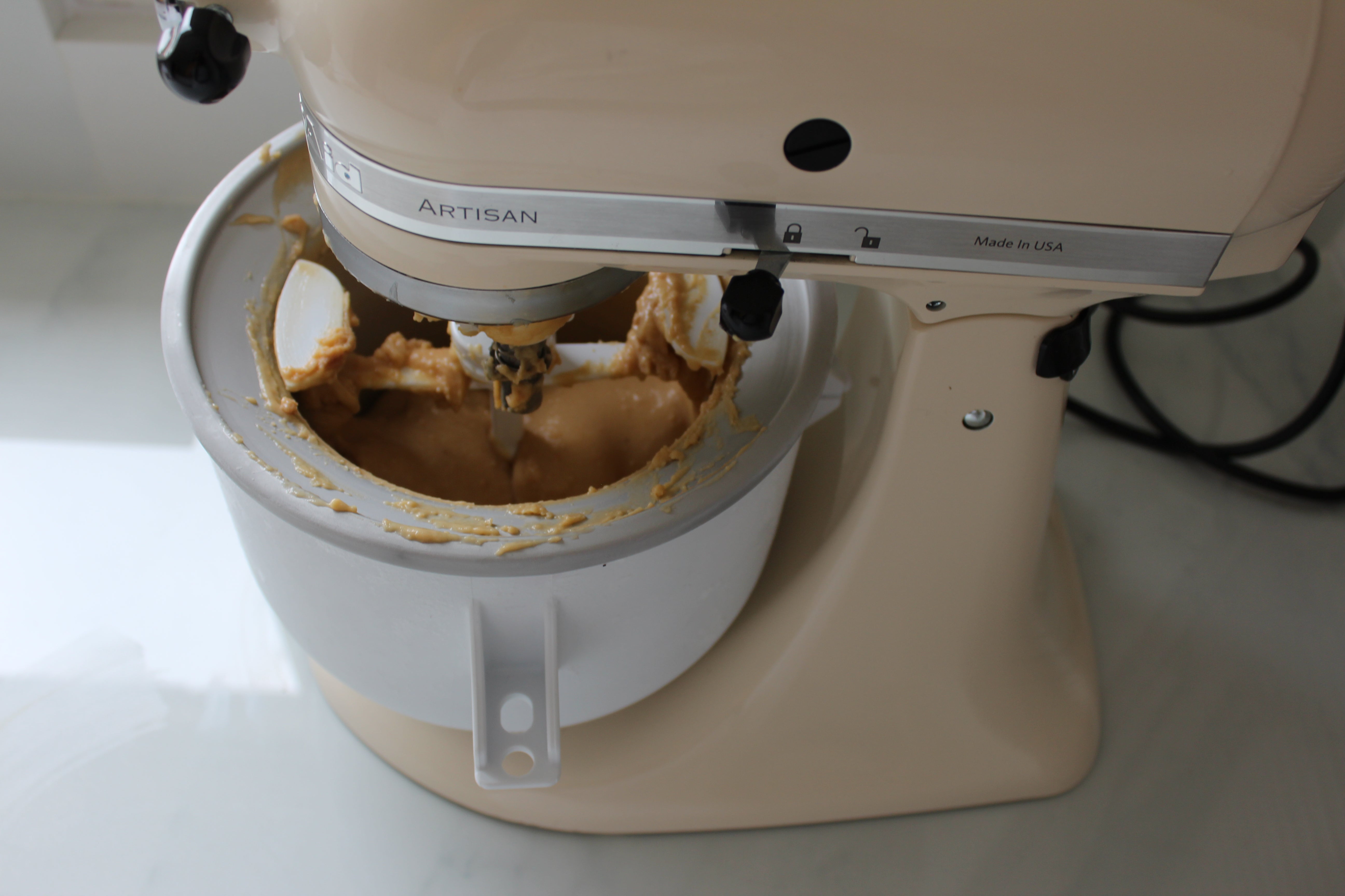 KitchenAid stand mixer with ice cream maker attachment in use.