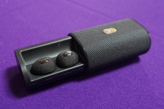 Jam Ultra wireless earbuds in charging case on purple background