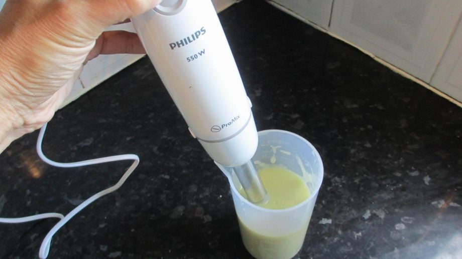 Philips hand blender in use blending ingredients in a glass