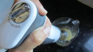 Hand holding Sage Control Grip blender with speed settings visible.