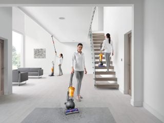 People using Dyson Light Ball vacuum in a modern home.
