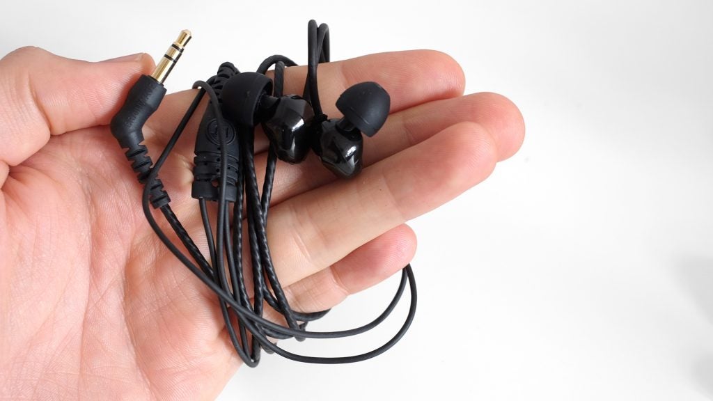 Hand holding Brainwavz B200 earphones with black cables