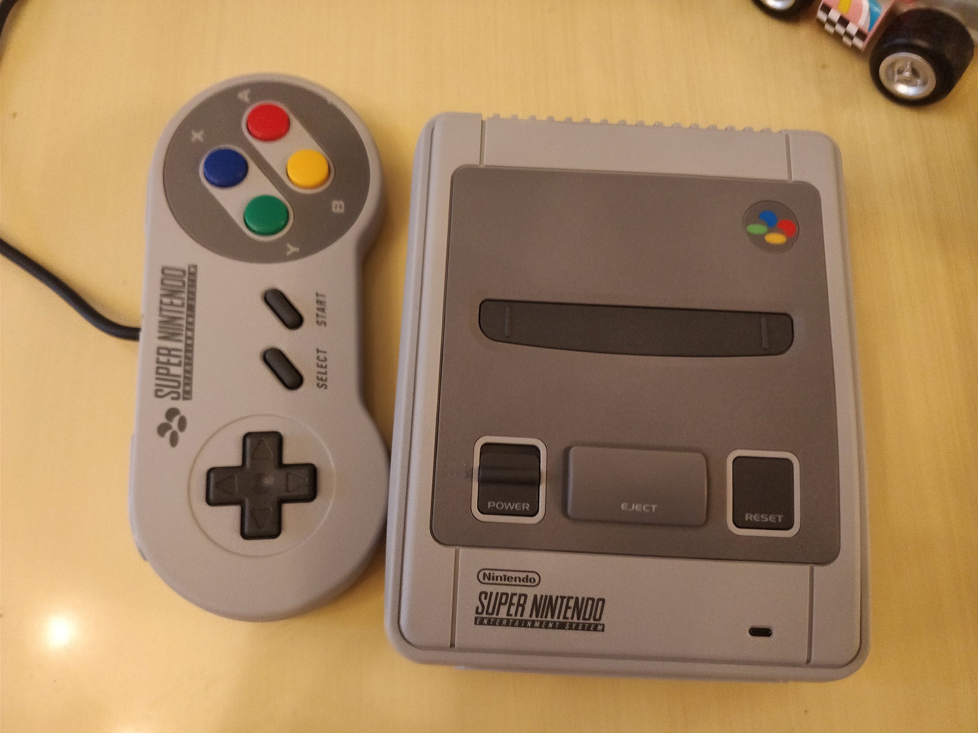 Nintendo Classic Mini SNES console and controller on table.