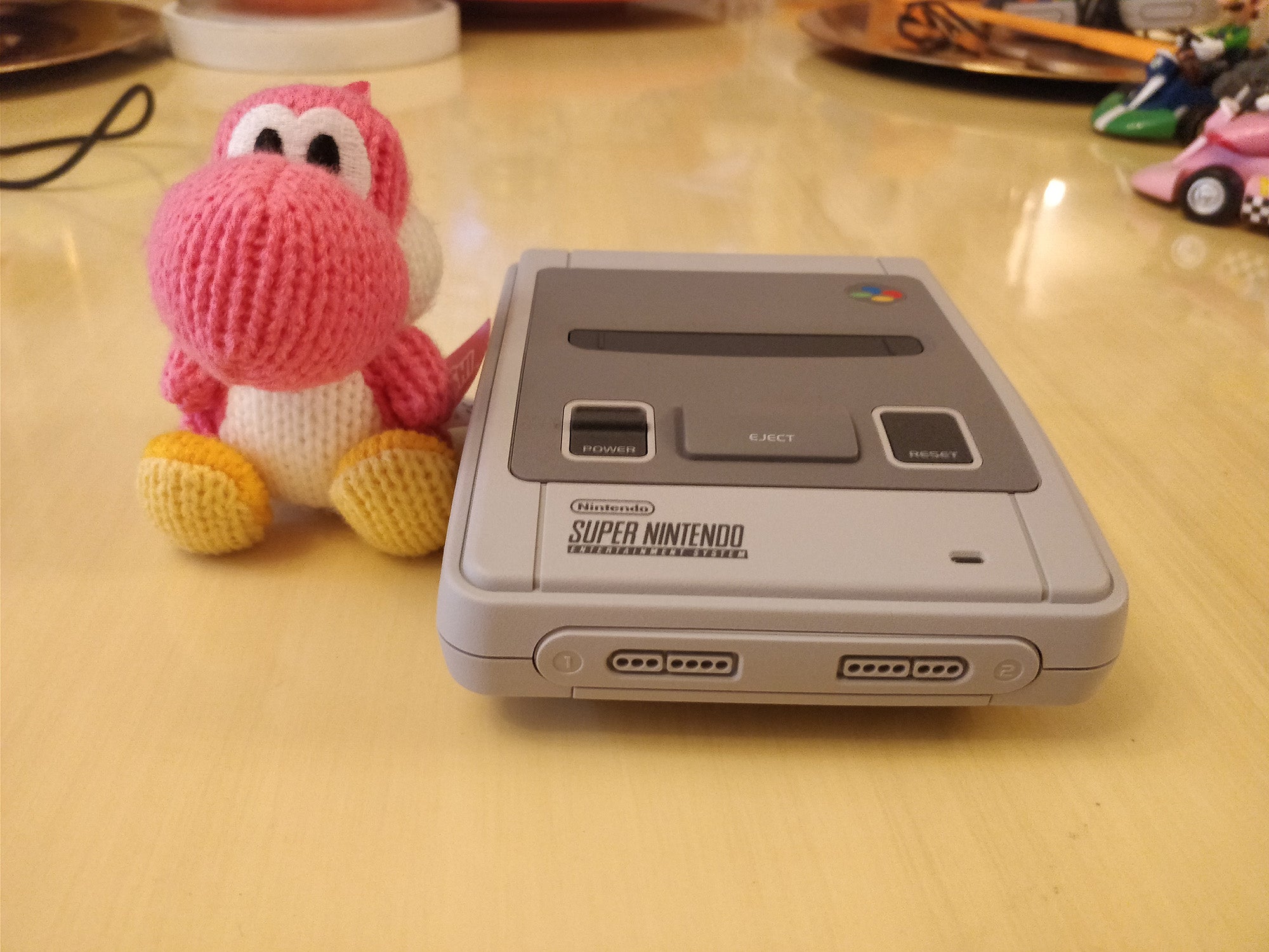 Nintendo Classic Mini SNES console with Yoshi plush toy.