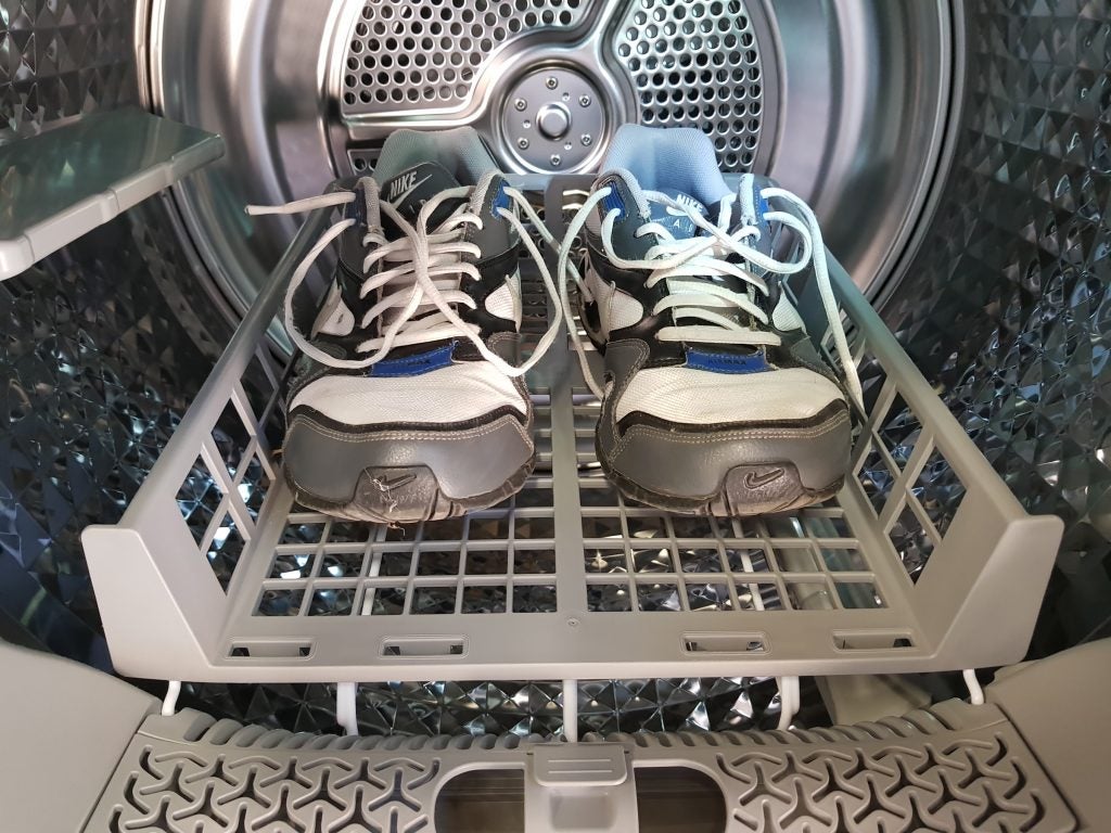 Sneakers inside Samsung dryer with shoe rack accessory.