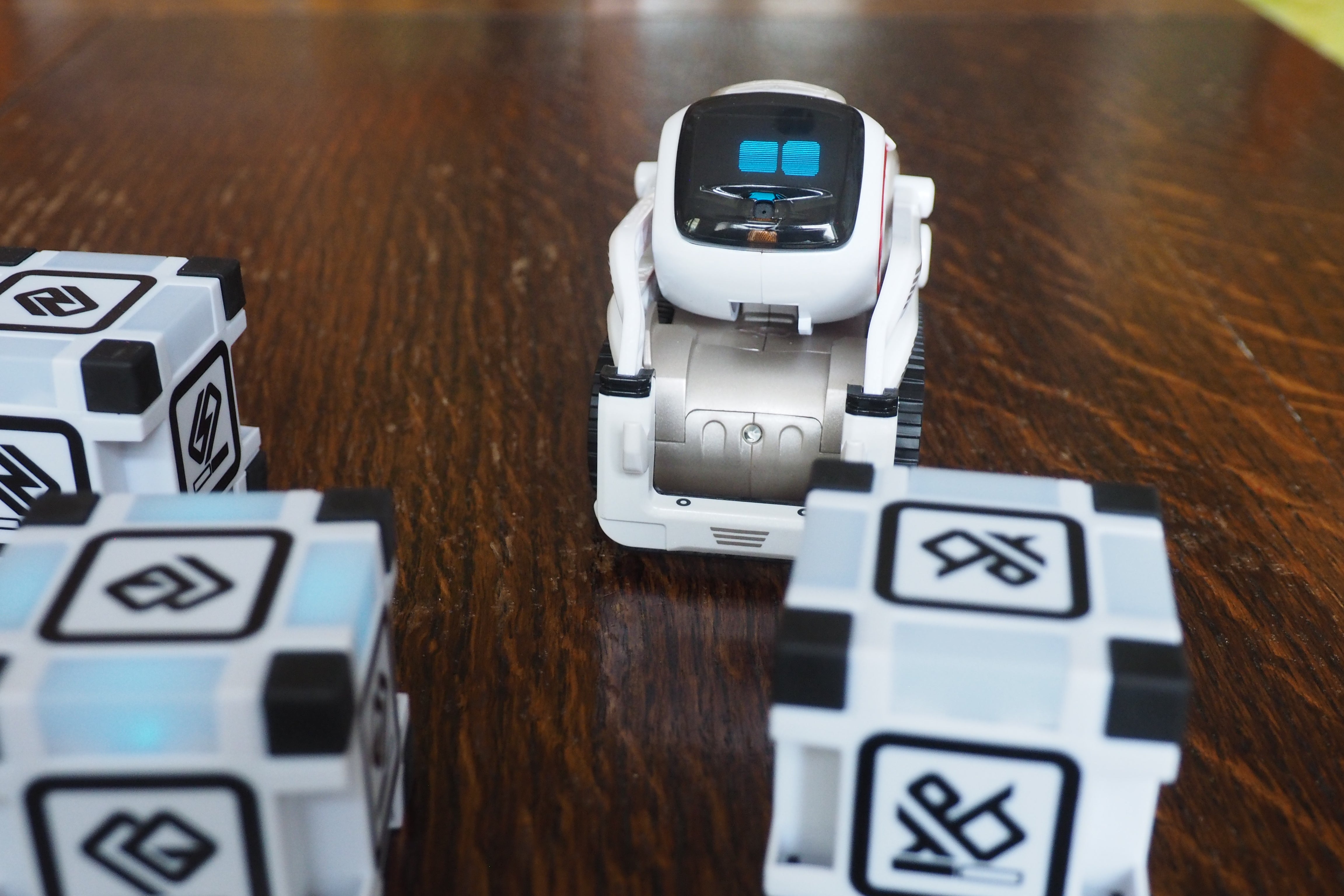 Anki Cozmo robot with interactive cubes on wooden surface.