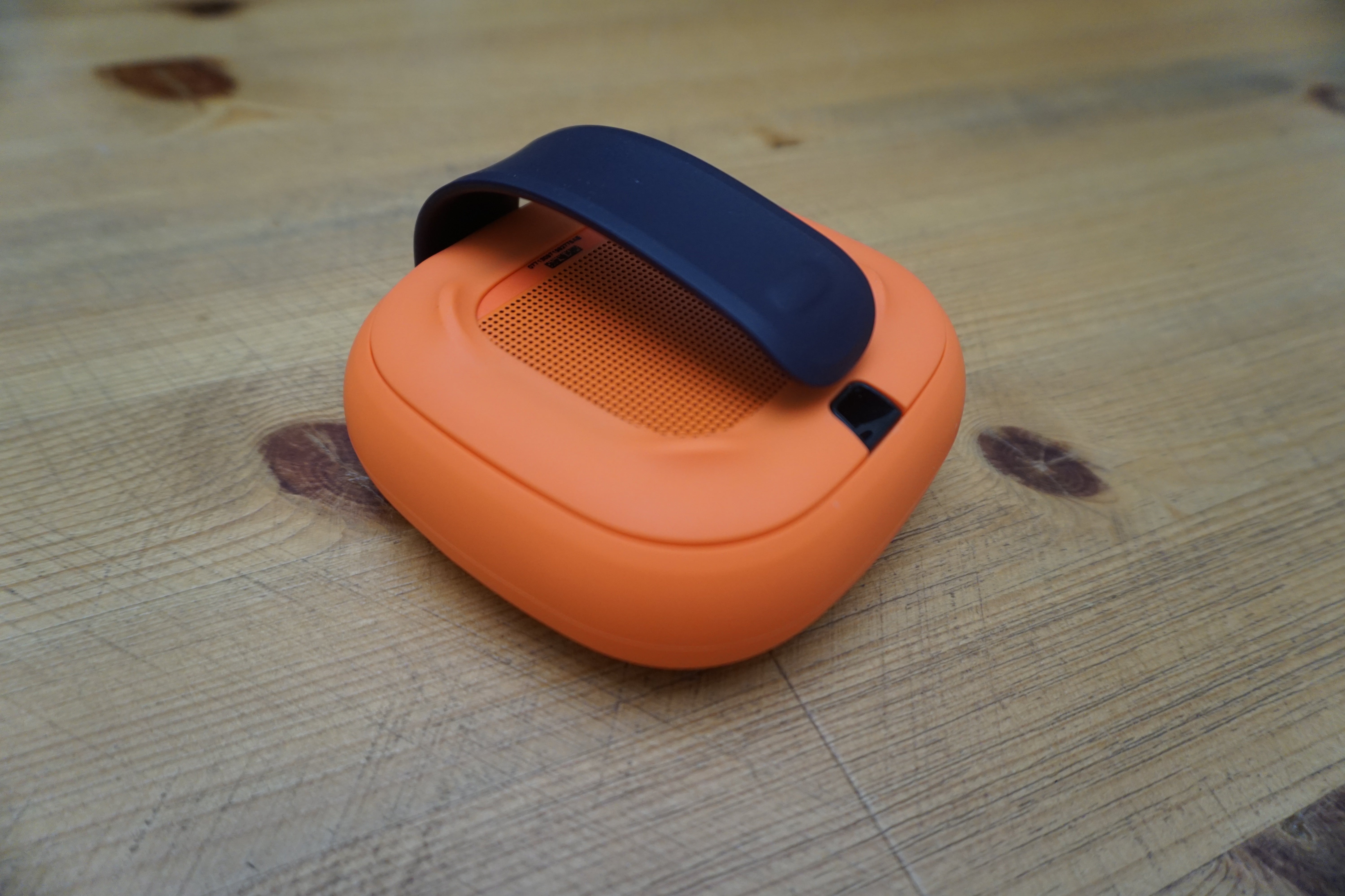 Bose SoundLink Micro speaker on wooden surface.