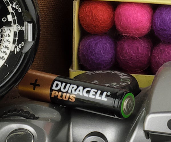 Fujifilm X-E3 camera alongside a Duracell battery and colored balls.