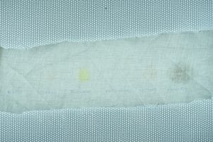Fabric with stains and handwritten wash test labels.