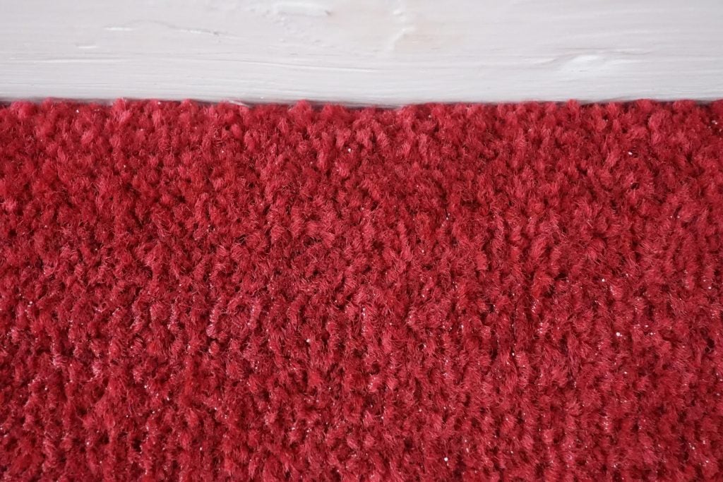 Close-up of clean red carpet texture after vacuuming.