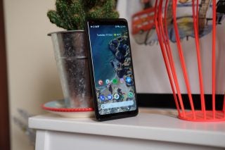 Google Pixel 2 XL smartphone on a white shelf beside a cactus.