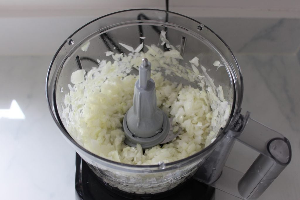 Bosch food processor with freshly chopped onions inside.
