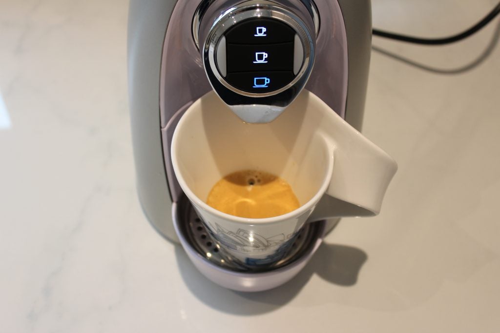 SO4 capsule machine dispensing espresso into cup.