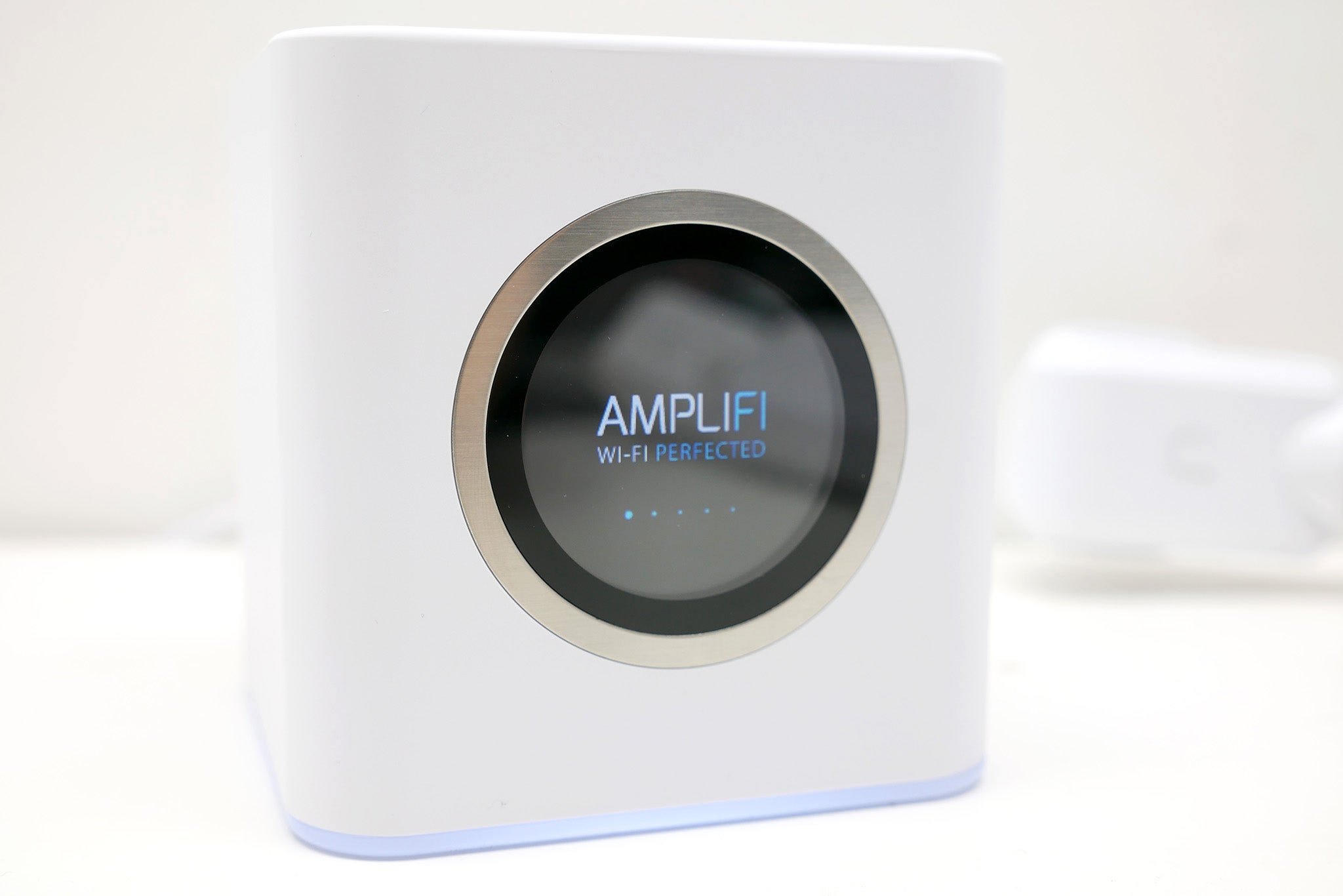 Ubiquiti AmpliFi router with LCD screen displaying logo.
