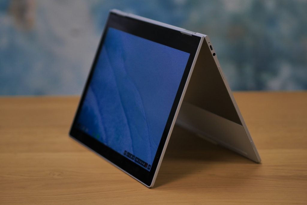 PixelBook on display with screen visible and accessories in background.PixelBook in tent mode on a wooden table.