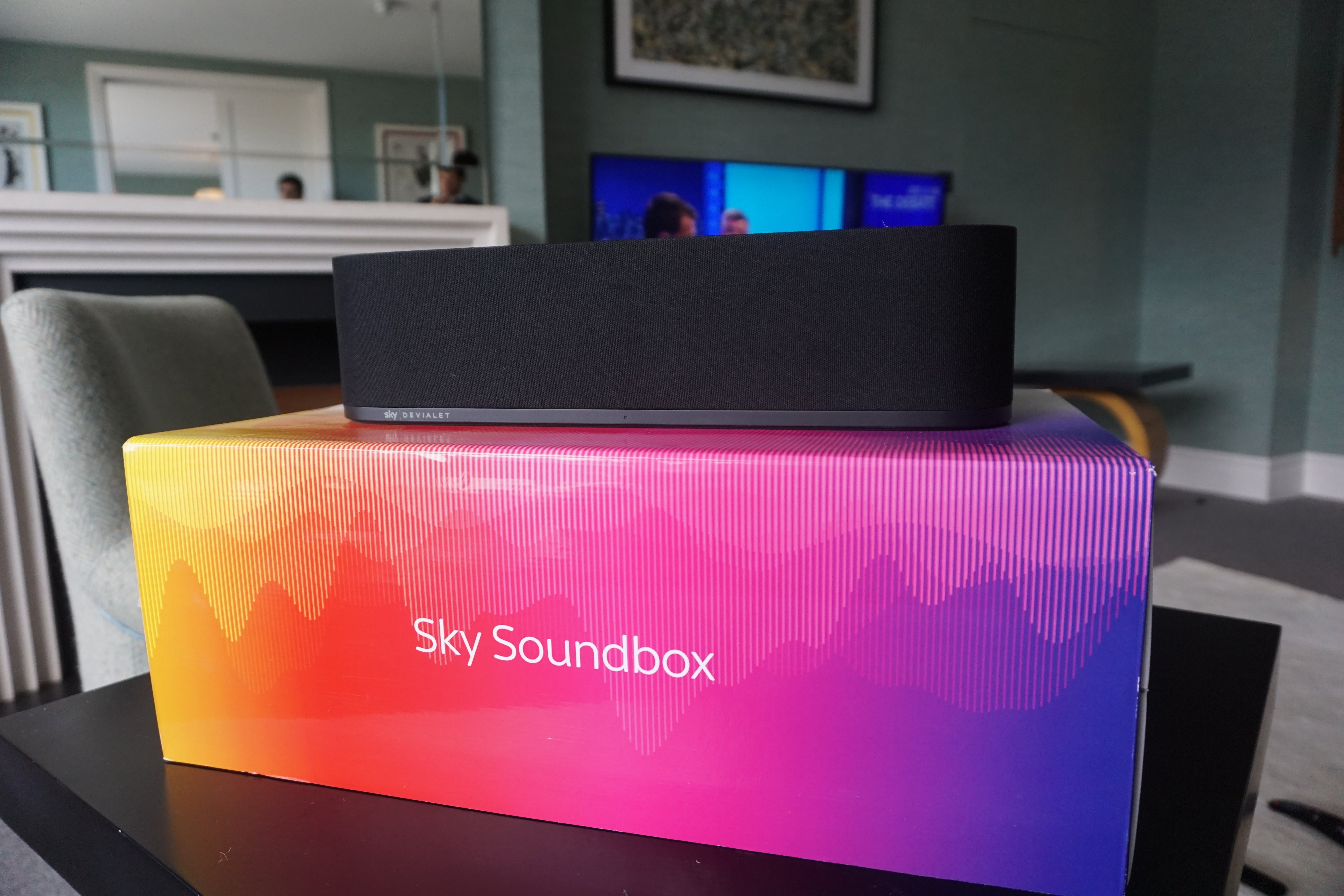 Sky Soundbox speaker on top of its colorful packaging.