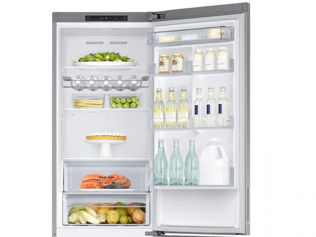 Samsung RB37J5018SA fridge freezer with open door and stocked shelves.