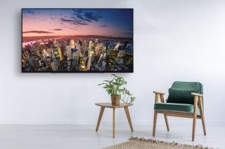 Toshiba 49U6763DB TV displaying cityscape on modern living room wall.